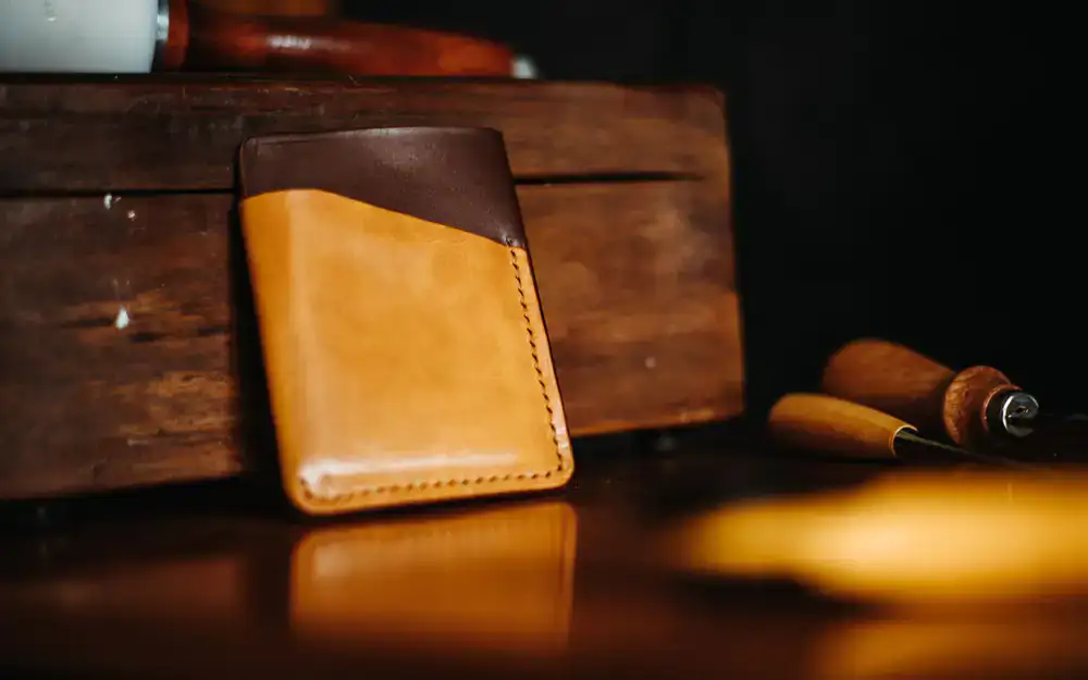 Hand stitched leather bifold wallet on dark surface